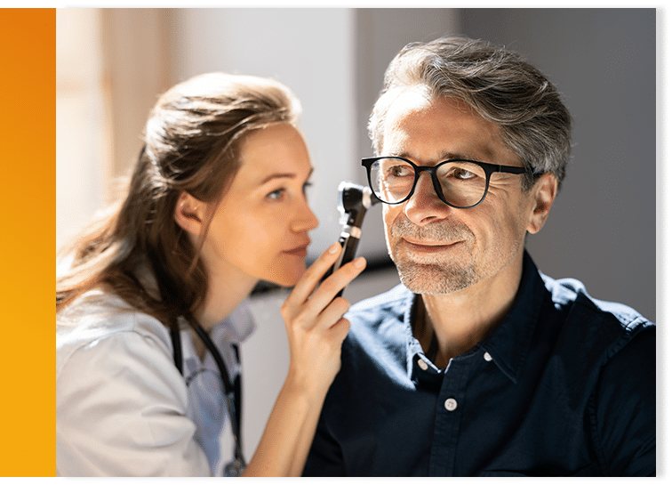 Audiologist checking patient's ears at the comfort of his home